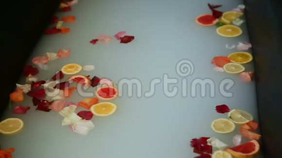 提供牛奶柑橘片和玫瑰花瓣的热美浴视频的预览图
