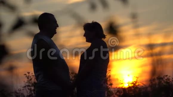 在夕阳的背景下男人和女人面对面视频的预览图
