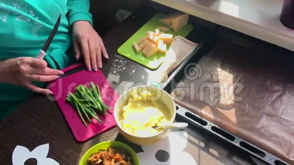 女人在切割板上切葱接下来的盘子是奶酪土豆泥和炸蘑菇视频的预览图