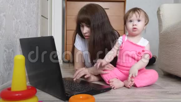 有孩子的年轻母亲在电脑工作视频的预览图