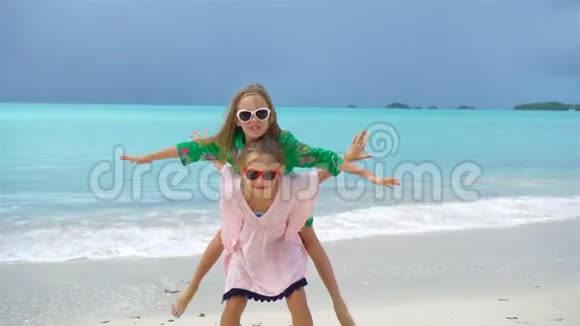 可爱的小女孩在热带海滩玩得很开心流动人口视频的预览图
