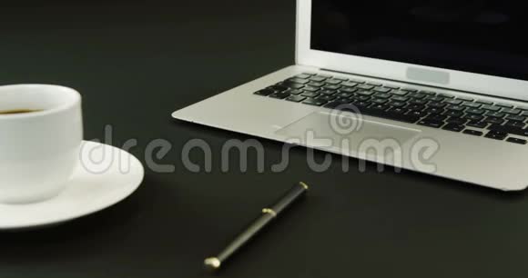黑色背景4k的笔记本电脑咖啡和笔视频的预览图