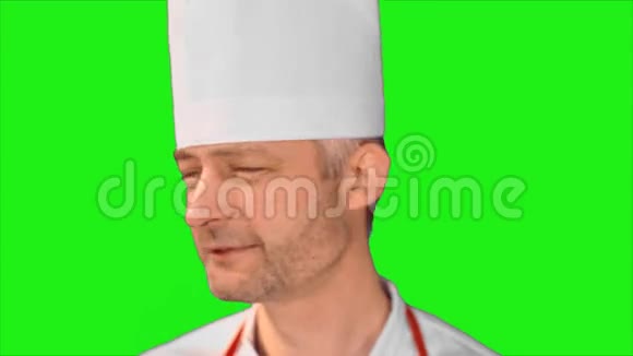 英俊的厨师转过头来微笑着看着相机转过身来露出绿色的背景视频的预览图