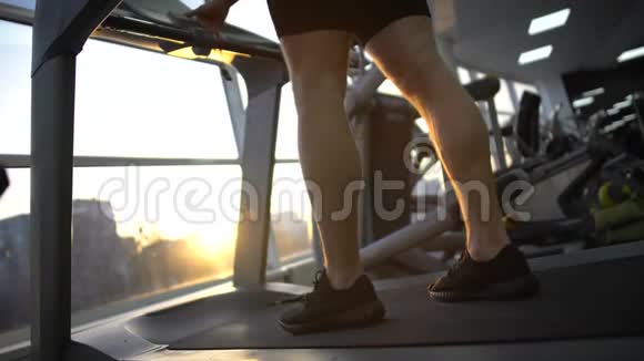 运动员在健身房跑步机上跑步锻炼前热身健康视频的预览图