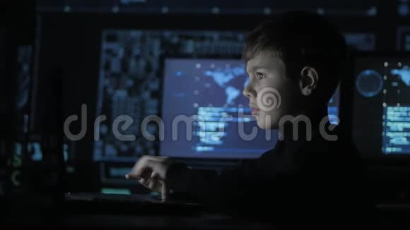 可爱的少年程序员在数据中心的一台电脑上工作里面装满了显示屏神童画像视频的预览图
