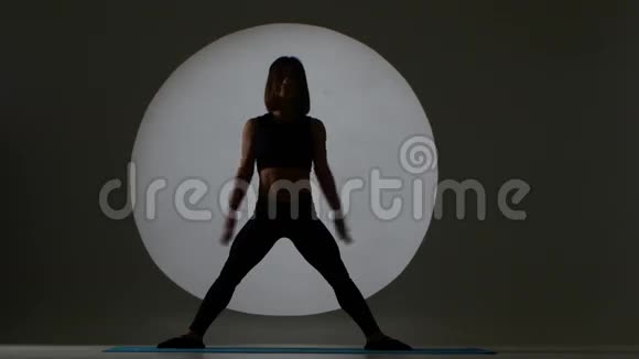 健身教练做下蹲运动型女人背光轮廓视频的预览图
