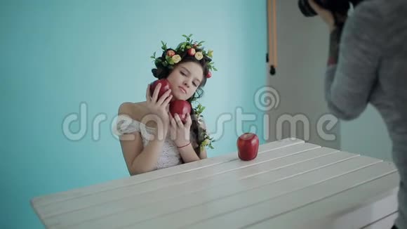 室内摄影时的后台拍摄女摄影师以春天的方式与年轻模特一起工作带着水果视频的预览图