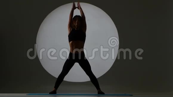 女人站在头上改变腿的姿势背光剪影视频的预览图