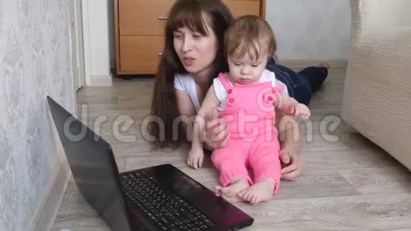 有孩子的年轻母亲在电脑工作视频的预览图