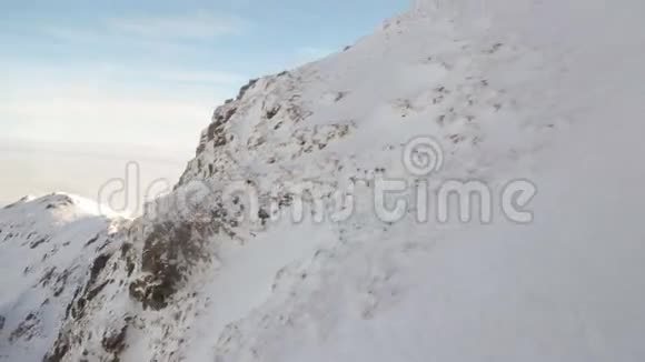 雪山峰鸟瞰沿斜坡滑动视频的预览图