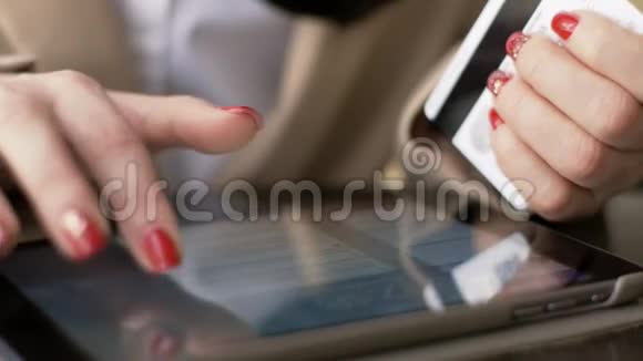 妇女在使用智能手机上网购物时会使用信用卡视频的预览图