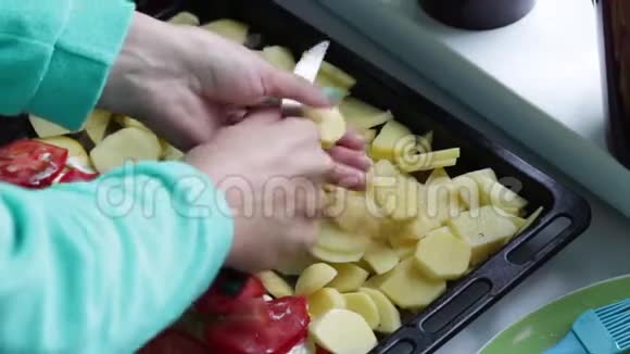 一个女人在烤盘上切土豆视频的预览图