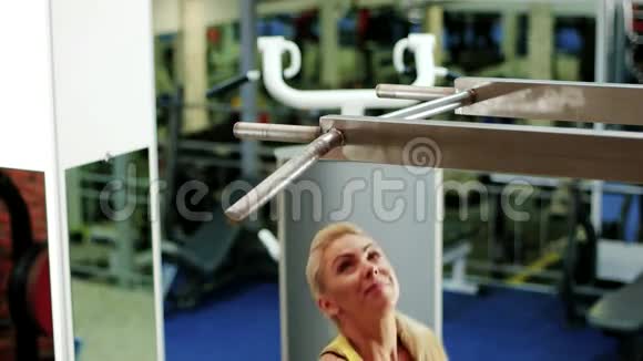运动的女人在健身房里女孩做一个拉起来的运动在水平杆上做运动作为一个运动视频的预览图