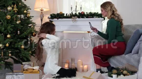 女孩制作照片手机女朋友正在准备平安夜女人说话笑坐在圣诞节附近视频的预览图