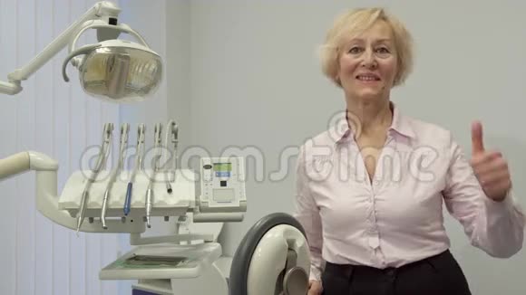 老太太在牙科诊所里竖起大拇指视频的预览图
