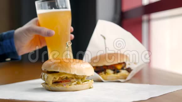 在现代咖啡馆里男人把啤酒和汉堡放在桌上视频的预览图