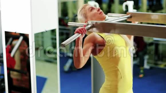 在水平杆上运动女孩做一个拉力运动运动的女人在健身房运动作为一个运动视频的预览图