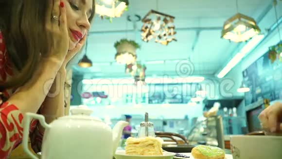 快乐的一对夫妇在咖啡馆吃甜点带着蛋糕的雷鬼女孩视频的预览图