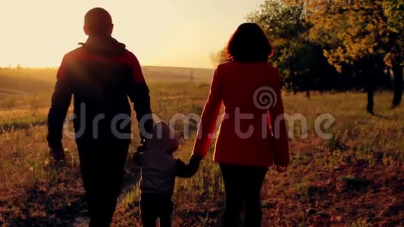 幸福的一家人在日落时在森林附近散步视频的预览图