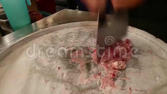 在街上煮着卷起来的冰淇淋冰淇淋小贩用草莓做冰淇淋的一部分冰激凌视频的预览图