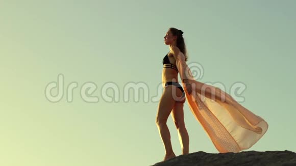 女孩穿着裙子在海边日落视频的预览图