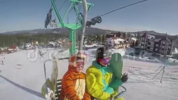 在阳光明媚的冬天两对有趣的滑雪者骑在滑雪电梯上1920x1080视频的预览图