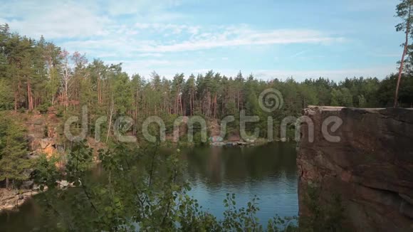 湖在石与岩石海岸美丽的湖泊和周围的绿树视频的预览图
