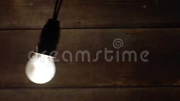 老式灯泡在旧木背景上摆动视频的预览图
