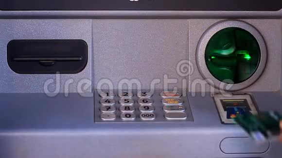 一个人把一张信用卡插入ATM机拨通密码然后从ATM机取出一张信用卡视频的预览图