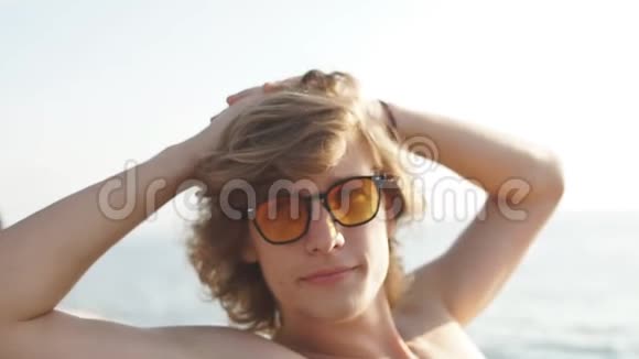 年轻的白种人时髦的家伙在游艇甲板上航行大海视频的预览图