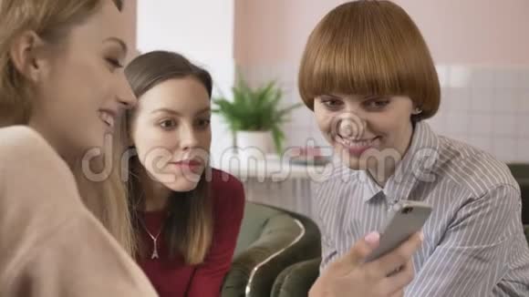 三个年轻女孩坐在咖啡馆里笑着微笑着朋友陪伴闲聊对话讨论女朋友视频的预览图