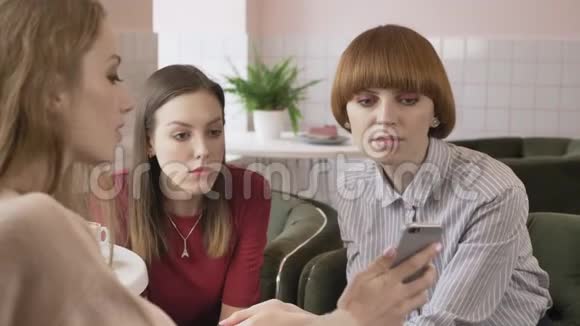 三个年轻的白种人女孩坐在咖啡馆里朋友陪伴闲聊对话讨论女朋友视频的预览图