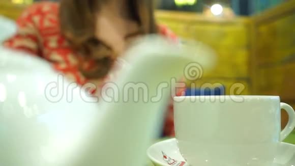 在咖啡馆喝绿茶的女孩近距离拍摄视频的预览图