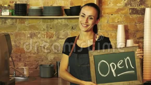 一个咖啡店的工人拿着一个开放的标志视频的预览图