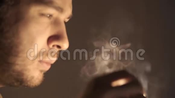 一个留着短胡子的人在黑暗中燃烧着火柴视频的预览图