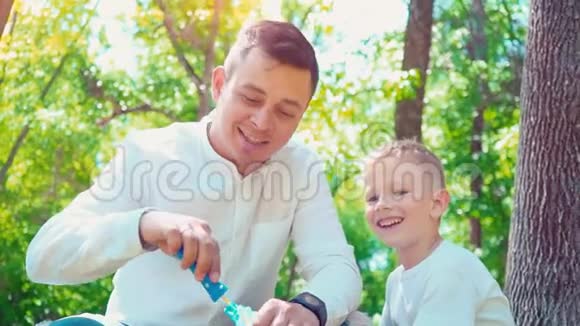 父亲和儿子吹肥皂泡家庭娱乐孩子和父亲玩得开心视频的预览图