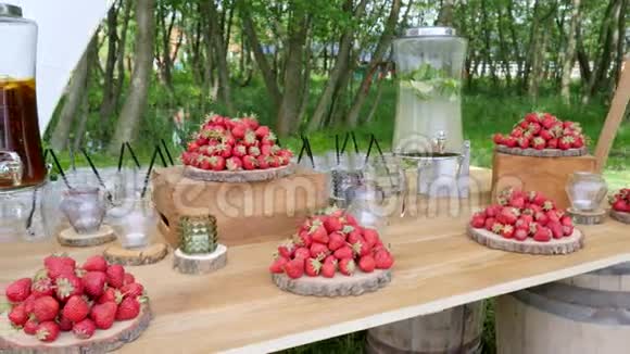 带有草莓的节日木桌带有凉茶和柠檬的水罐不含酒精的莫吉托背景性质视频的预览图