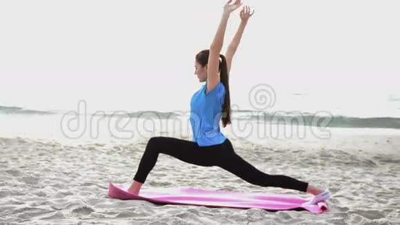 日落时分年轻女子在沙滩上做瑜伽运动视频的预览图
