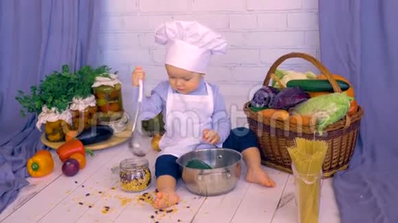 可爱的男婴在厨房做饭玩扁豆银行视频的预览图