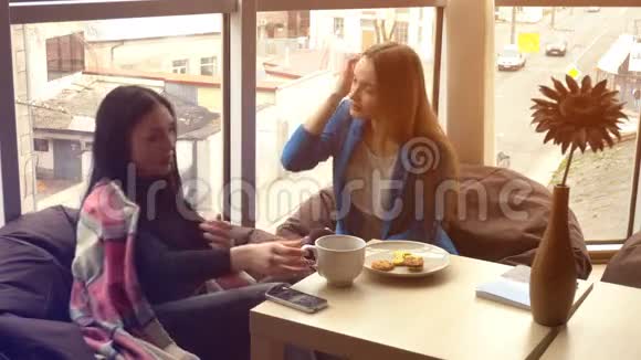 两个女孩在咖啡厅里谈笑风生视频的预览图