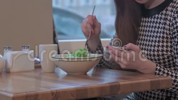 年轻女商人使用智能手机进行交流的武器她正坐在咖啡馆的桌子旁吃着沙拉视频的预览图