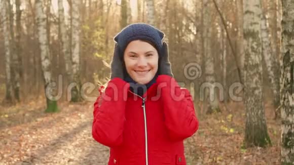 快乐的微笑女人享受大自然站在秋天的公园里年轻漂亮的女人在镜头前微笑视频的预览图