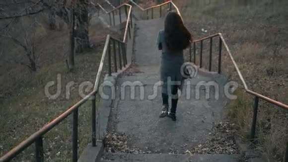 小女孩走在奥图姆街的老楼梯旁视频的预览图