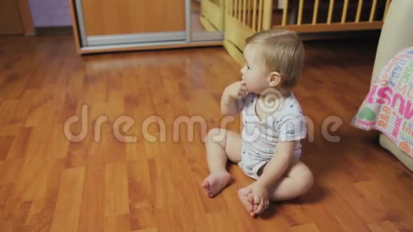 小男孩坐在房间的地板上视频的预览图
