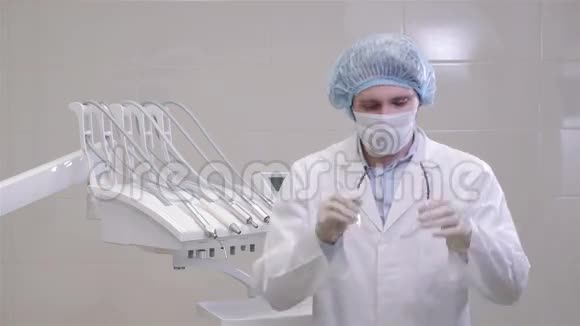 戴着口罩和帽子的医生站在牙科诊所的手术室里视频的预览图