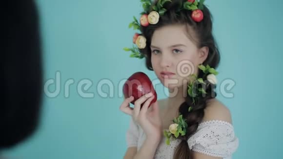 女摄影师以春天的方式与年轻模特一起工作并在工作室带着水果室内拍摄的后台镜头视频的预览图