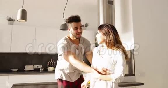 年轻混血情侣拥抱厨房晨曦可爱快乐西班牙男人亚洲女人拥抱视频的预览图