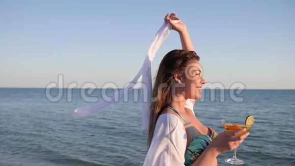 沙滩上的女孩模特海上的夏日休息年轻女性的鸡尾酒视频的预览图