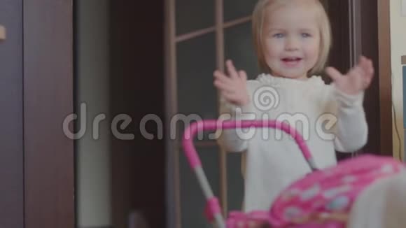 小女孩在房子里玩玩具婴儿车视频的预览图