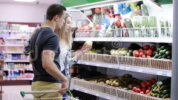 年轻夫妇在超市里摘蔬菜视频的预览图